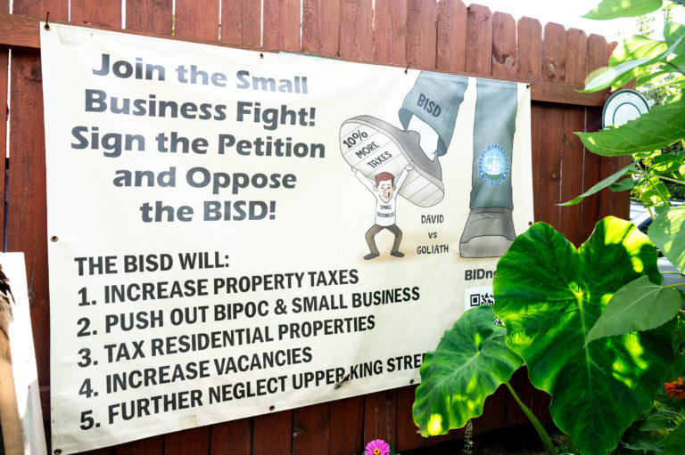 Sign showing a little business owner being crushed